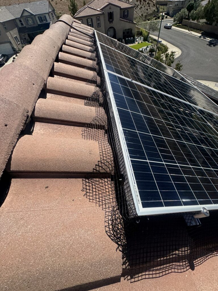 Bird proofing mesh fitted around solar panels on Spanish S-tile roof
