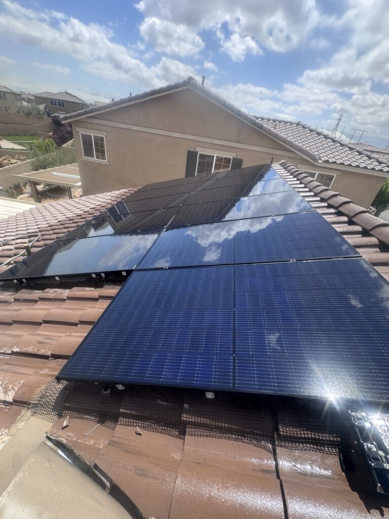 Freshly cleaned solar panels reflecting clouds on a tile roof